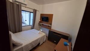 a small room with a bed and a television at Studio Executivo Completo com Garagem , Ar e Wi-fi in Parauapebas
