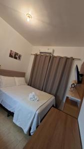 a bedroom with a bed with two white towels on it at Studio Executivo Completo com Garagem , Ar e Wi-fi in Parauapebas