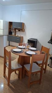 a wooden table with chairs and wine glasses on it at Studio Executivo Completo com Garagem , Ar e Wi-fi in Parauapebas