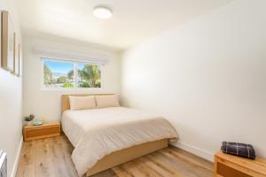 a white bedroom with a bed and a window at Carpinteria Shores CS 210 in Carpinteria