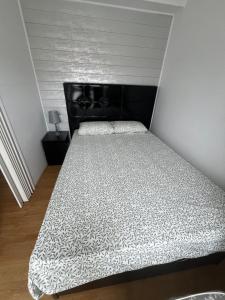 a bed with a black headboard in a room at La Casina del Puerto in Luarca