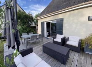 a patio with a table and chairs and an umbrella at Independent studio - Cicé Blossac Golf in Bruz