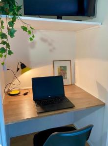a laptop computer sitting on a wooden desk at Independent studio - Cicé Blossac Golf in Bruz