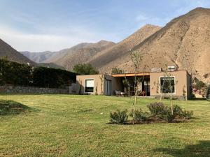 a house in a field with mountains in the background at Casa de Campo Urpichay in Ricardo Palma