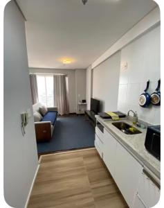 a kitchen and a living room with a couch at The Cittyplex Osasco - new flat in Osasco