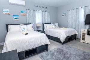 a bedroom with two beds and a tv in it at Villa By the Beach - sleeps 6 plus in Nassau