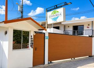 a house with a wooden gate and a sign at Escápate a Jacó apartamento completo in Jacó