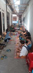 a group of people sitting on the floor in a building at Bulan Bungalows and Cafe in Tetebatu
