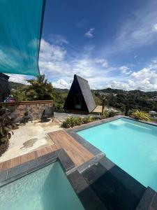 a swimming pool in front of a house with a tent at Vibra Barranquitashot pool in Barrancas