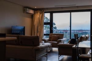 a living room with couches and a large window at Beaufort Ridge - Skysuites in Accra
