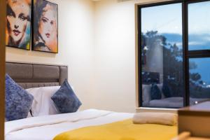 a bedroom with two beds and a window at Beaufort Ridge - Skysuites in Accra