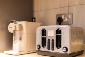 a toaster sitting next to a coffee maker on a counter at Beaufort Ridge - Skysuites in Accra