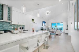 a kitchen with white cabinets and a dining room at Grace Bay Beach Front Penthouse in Long Bay Hills