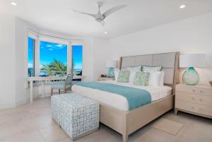 a bedroom with a bed with a view of the ocean at Grace Bay Beach Front Penthouse in Long Bay Hills
