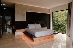 a bedroom with a bed and a large window at ECO HOTEL RIO DE ORO in San Rafael