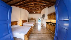 a bedroom with two beds and a kitchen at Finca Hotel Monte Carlos in Santa Bárbara