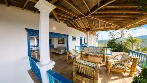 a patio with chairs and a table on a porch at Finca Hotel Monte Carlos in Santa Bárbara