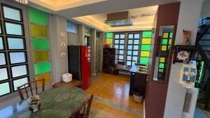 a kitchen with colorful glass windows and a table at Cozy two-storey home in Ban Lam Praya Phai Rua