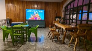 a room with tables and chairs and a television at Hostel Paricutín in Uruapan del Progreso