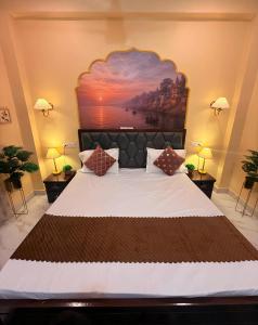 a bedroom with a large bed with a painting on the wall at Sukoon e Banaras in Varanasi