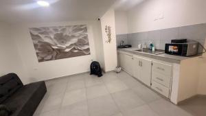 a kitchen with a couch and a sink and a microwave at Hotel Boutique Trinitarias in Valledupar