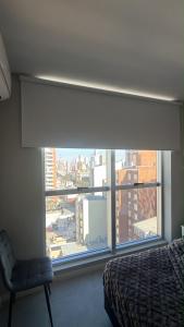 a bedroom with a window with a view of a city at Departamento Excelente Ubicación - Torre Fenix in Santa Fe