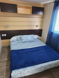 a bedroom with a bed with a blue blanket at Residencial Robles in Sanlúcar de Barrameda
