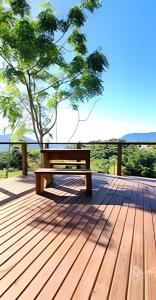 a wooden bench sitting on top of a wooden deck at Imperatriz Cabanas (Chalé 1 com hidromassagem) in Santo Amaro da Imperatriz