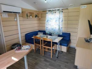a small room with a table and a blue couch at Residencial Robles in Sanlúcar de Barrameda