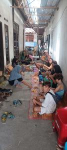 a group of people sitting on the floor in a building at D'Bulan bungalows and kafe in Tetebatu