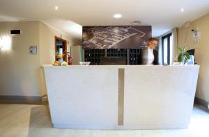 a woman standing at a counter in a restaurant at Hotel San Rocco in Muggia