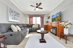 a living room with a couch and a ceiling fan at Morpeth Cottage in Morpeth