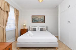 a bedroom with a white bed and a window at Morpeth Cottage in Morpeth