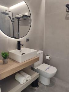 a bathroom with a sink and a toilet and a mirror at Principe in Sanxenxo