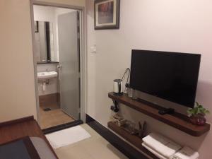 a bathroom with a television and a bathroom with a sink at De Benz Inn in Malacca +37 photos