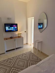 ein Schlafzimmer mit Spiegel und Fernseher an der Wand in der Unterkunft Dimora morgese in Castellana Grotte