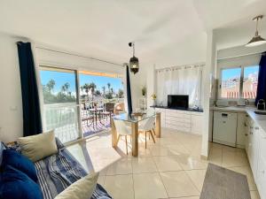a living room with a table and a kitchen with a view at Apartamento El Nido in Torre del Mar +8 photos
