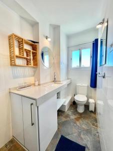 a white bathroom with a sink and a toilet at Apartamento El Nido in Torre del Mar