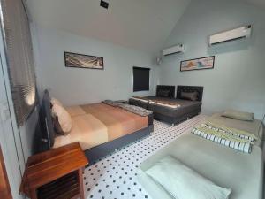 a small room with two beds and a couch at Numhom Resort in Ban Nong Chum Saeng