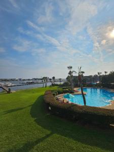 a swimming pool in a park next to a body of water at Salty Love Nest in Fort Walton Beach