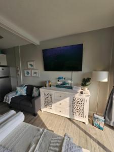 a living room with a flat screen tv on a wall at Salty Love Nest in Fort Walton Beach
