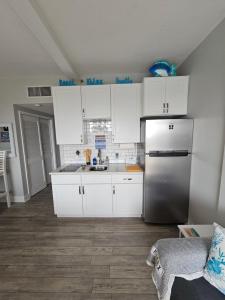 a kitchen with white cabinets and a stainless steel refrigerator at Salty Love Nest in Fort Walton Beach
