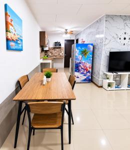 a kitchen and dining room with a wooden table and chairs at Escápate a Jacó apartamento completo in Jacó