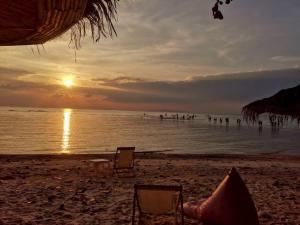 a beach with two chairs and the ocean at sunset at Umbrella tree v1 in Nathon +3 photos