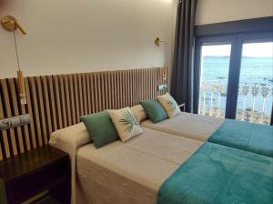 a bedroom with two beds and a large window at Principe in Sanxenxo