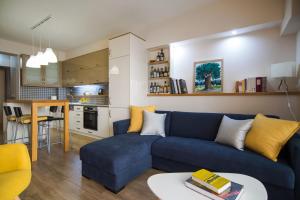 a living room with a blue couch and a kitchen at Kyan Bay in Itea