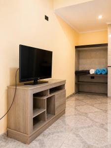a flat screen tv sitting on top of a wooden entertainment center at JM Resort Iguazu in Puerto Iguazú