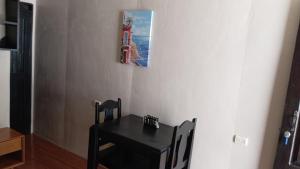 a black table with chairs and a picture of a lighthouse at Apartamentos Caimán 3 in Tortuguero