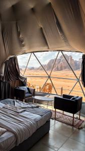 a room with two beds and a view of the desert at RUM PRESTIGE lUXURY CAMP & DESERT TOURS in Wadi Rum