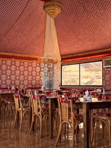 a restaurant with wooden tables and chairs and a red ceiling at RUM PRESTIGE lUXURY CAMP & DESERT TOURS in Wadi Rum